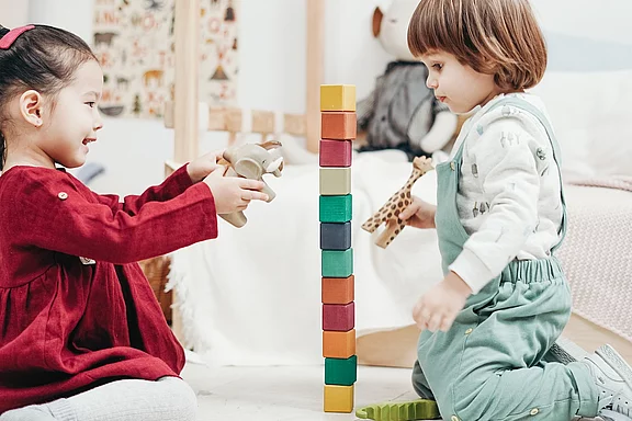 Zwei Kinder spielen in einem Spielzimmer.