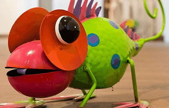 Chamäleon aus Blech auf einem Holzboden